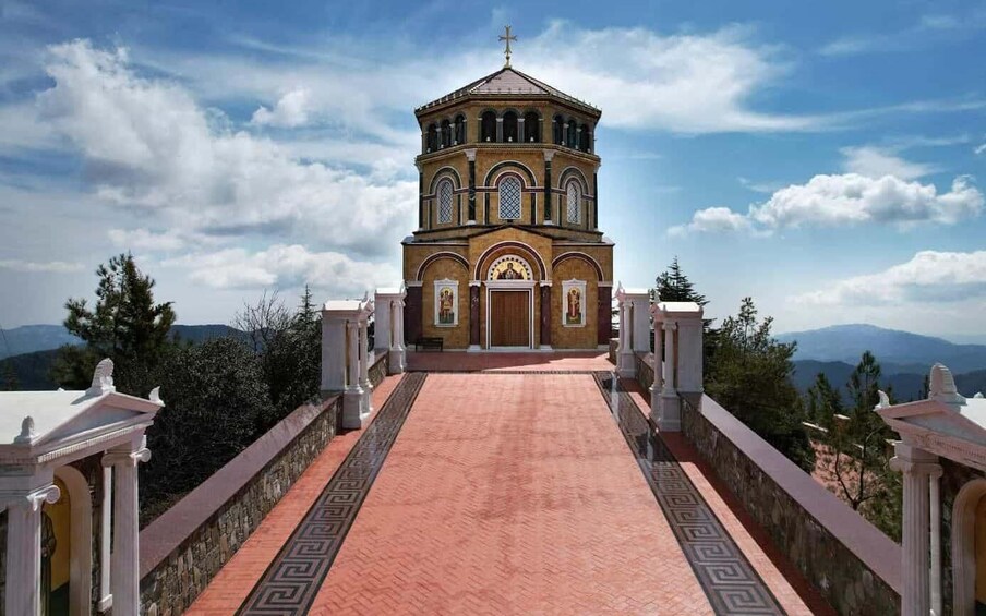 A church with a central dome and a red-tiled walkway leading to it. 2