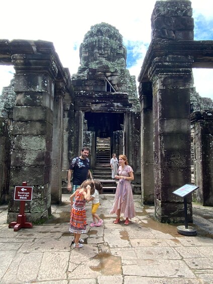 A stone temple entrance with a sign indicating the way of visit. 5
