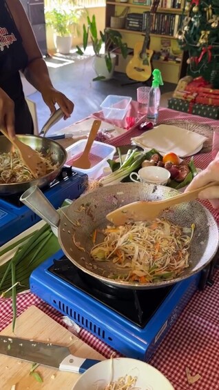 A person cooking stir-fried vegetables on a portable stove. 1
