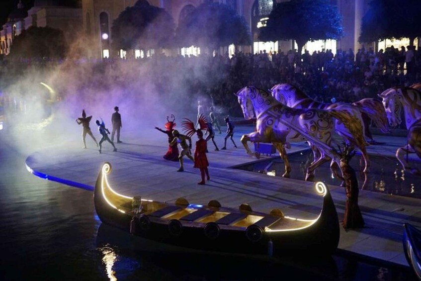 A nighttime outdoor performance with performers in costumes, a boat, and a crowd. 2