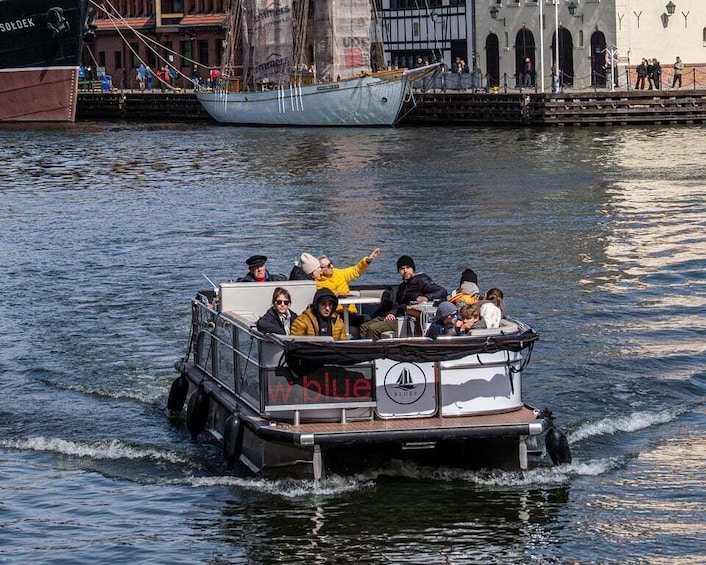 A boat with passengers, a docked ship, and buildings in the background. 4