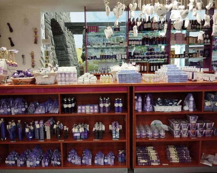 A store with shelves of purple and blue packaged goods, a stone archway, and hanging white objects. 2