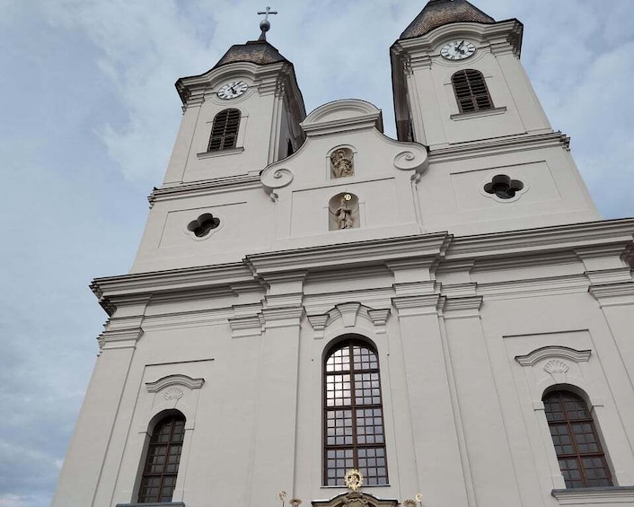 A white church with two towers, each with a clock and a cross on top. 5