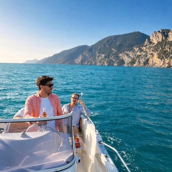 Two people on a boat with a mountainous coastline in the background. 5