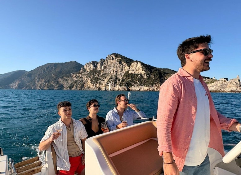 A group of people on a boat with rocky cliffs in the background. 3