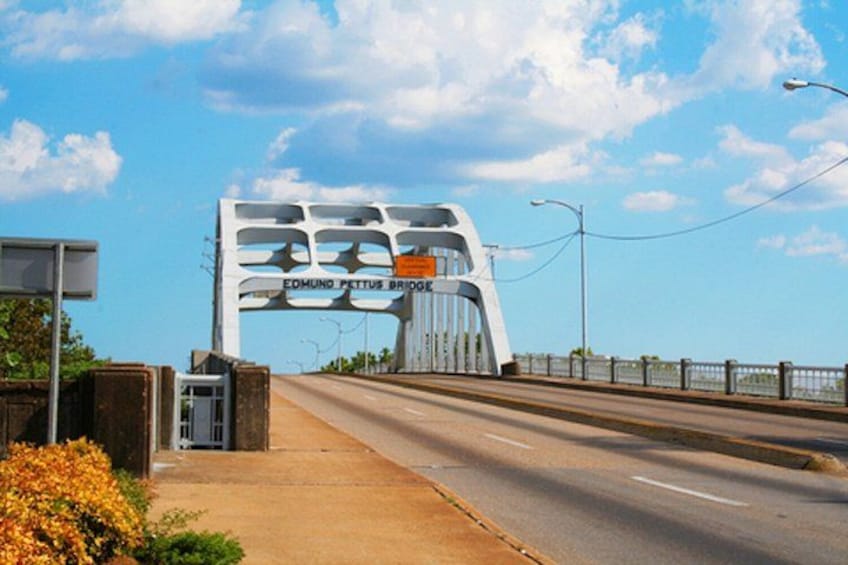 A bridge with a unique design, a clear sky, and a sidewalk on the left. 3