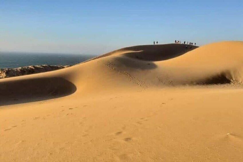 Sand dunes with footprints and a clear sky. 3