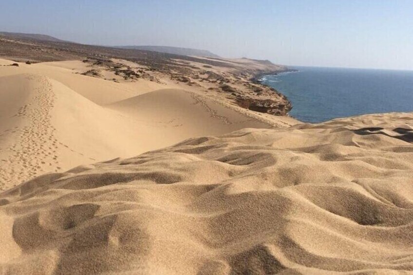 Sand dunes, a coastline, and a clear sky. 2