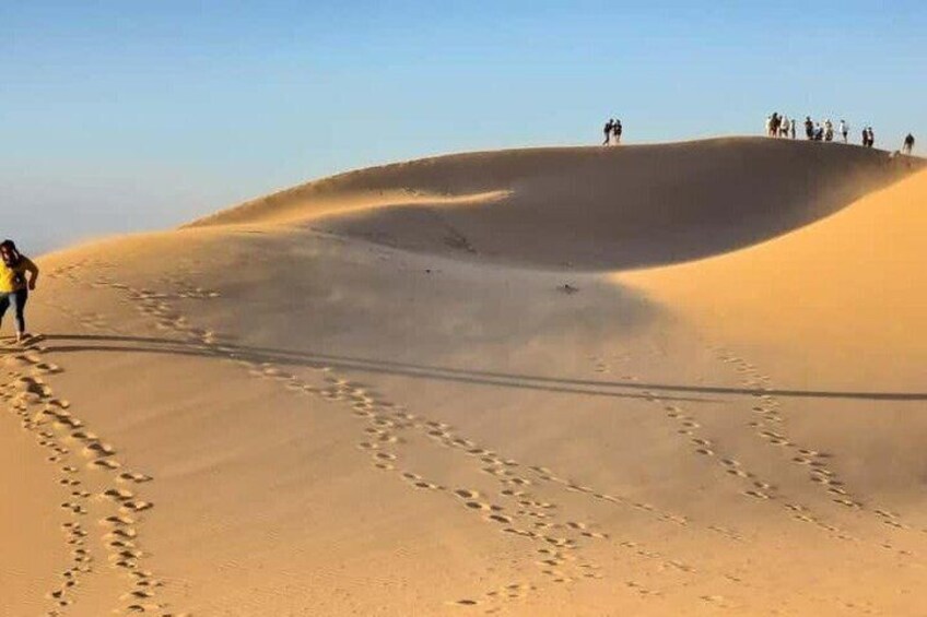 A desert landscape with sand dunes and footprints. 1