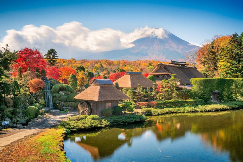 A traditional Japanese garden with a pond, thatched-roof buildings, and a waterfall. 3
