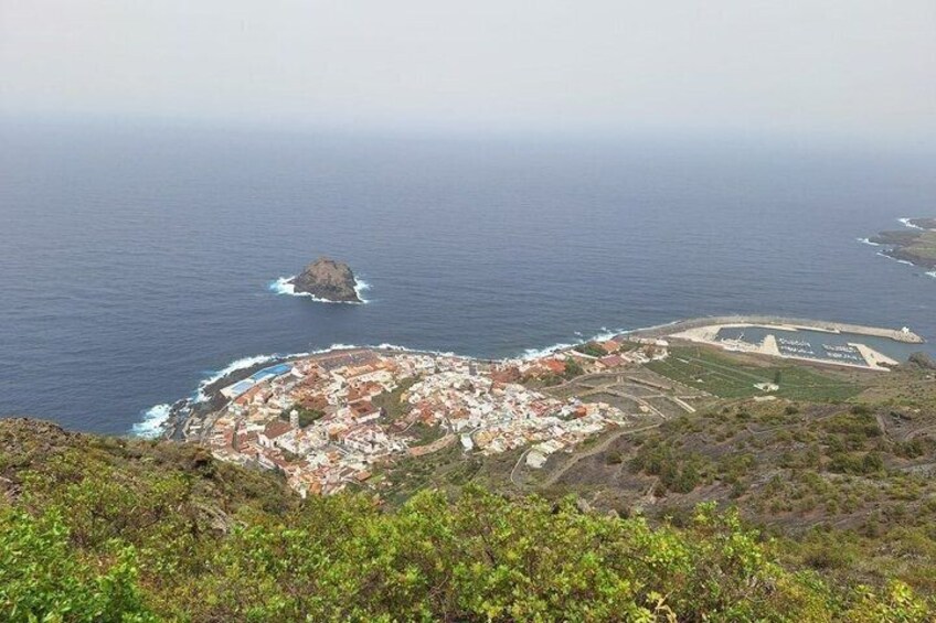 A coastal town with a central plaza, a small island nearby, and a clear view of the ocean. 3
