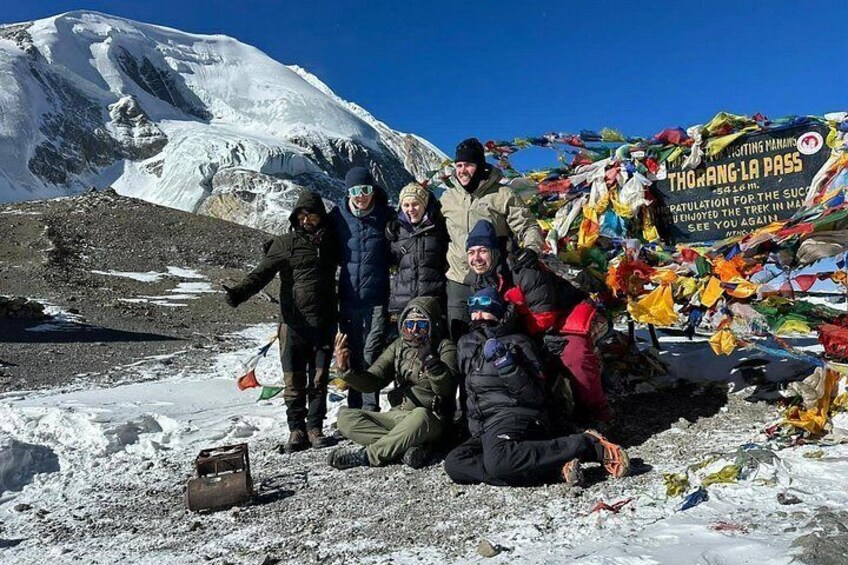 A group of people in a snowy mountainous area with a banner and prayer flags. 1