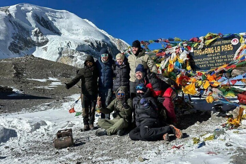 A group of people in a snowy mountainous area with a banner reading 'Tholing La Pass.' 1