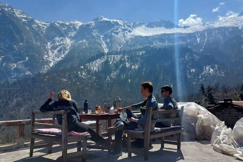 Three people seated at a table with a mountain view. 4