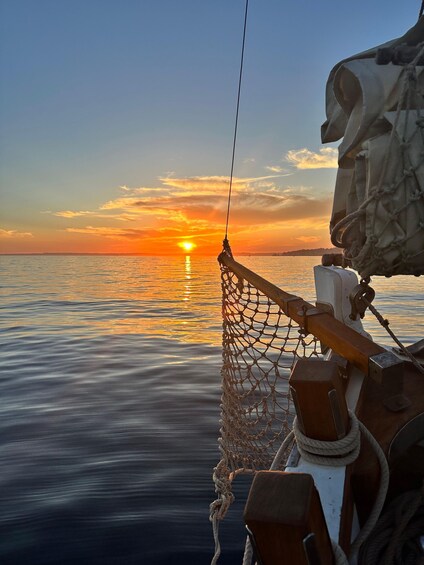 A calm sea at sunset with a fishing net and boat equipment. 1