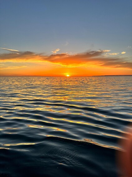A sunset over a calm sea with reflections of the sky. 2