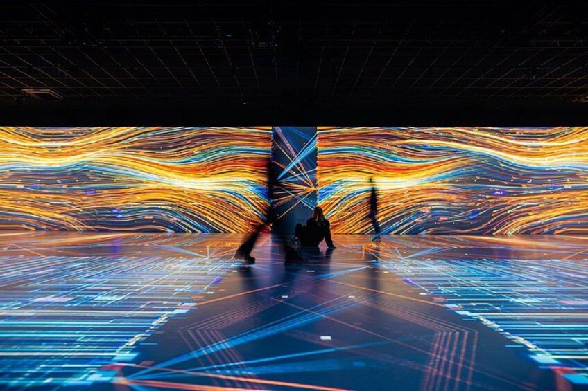 A person walking through a tunnel with vibrant light trails. 2
