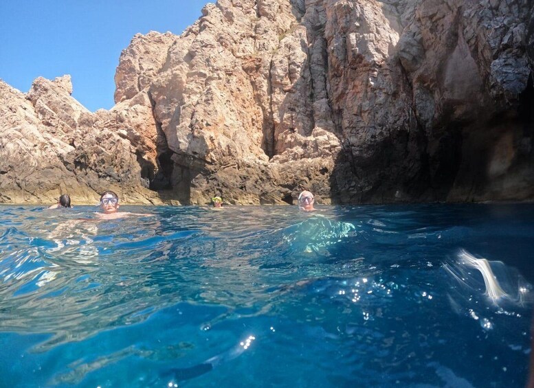 Clear blue water with rocky cliffs in the background. 1