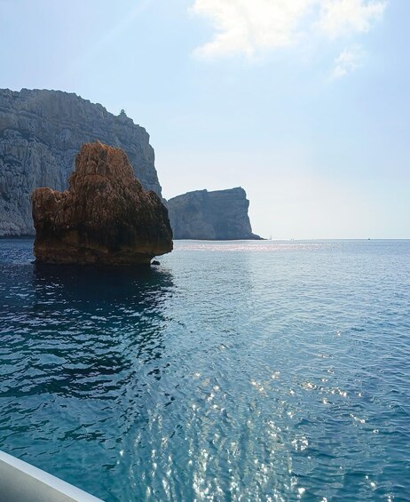 A calm sea with rocky cliffs and a clear sky. 3