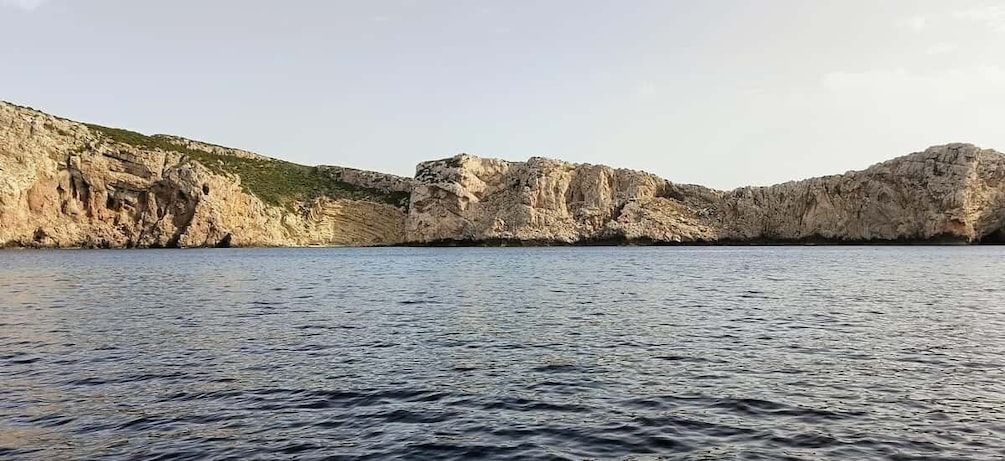 A coastal landscape with rocky cliffs and calm sea. 5