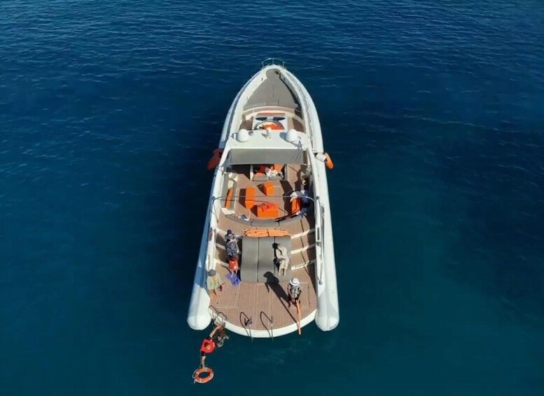 A boat with a wooden deck, life jackets, and a person standing at the bow. 3