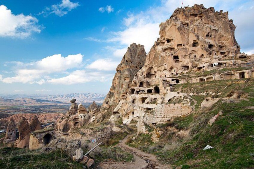 A rocky mountain with ancient cave dwellings and a clear sky. 3