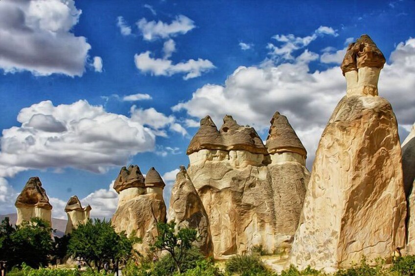 A landscape with tall, unique rock formations under a blue sky with clouds. 2