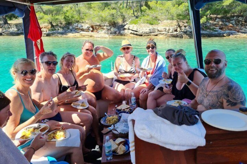 A group of people on a boat with a turquoise sea in the background. 5