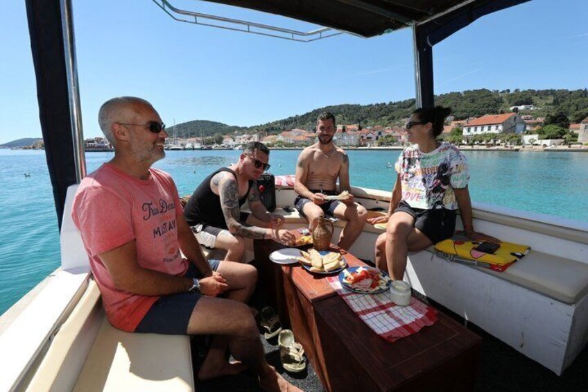 A group of people on a boat with a coastal landscape in the background. 4