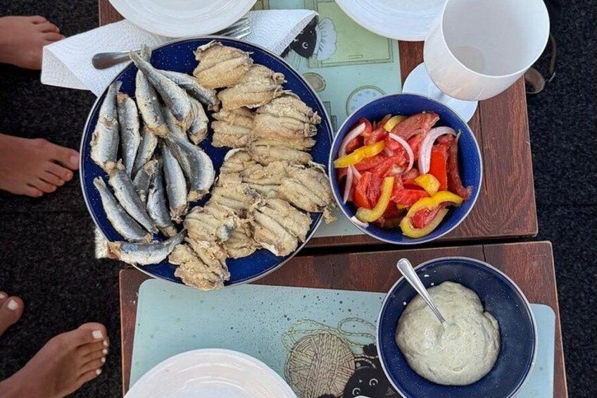 A table with a plate of fish, a bowl of sliced vegetables, and a bowl of sauce. 2