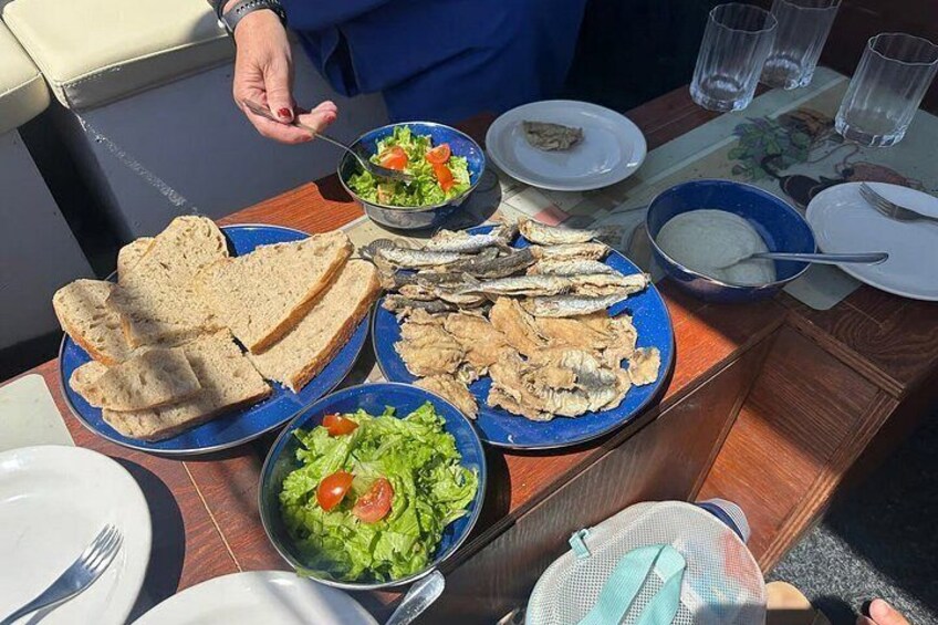 A table with plates of food, including fish, bread, and salad. 1