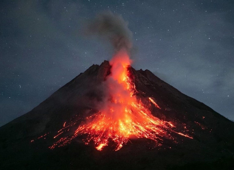 A volcano erupting at night with lava flowing down its side. 2