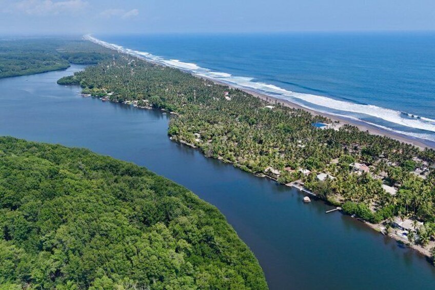 A coastal landscape with a river, beach, and forested areas. 5