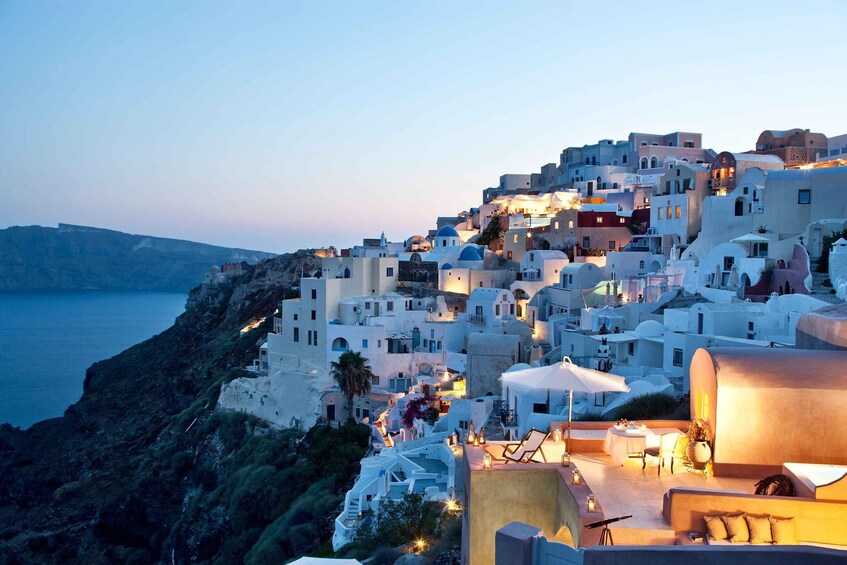 A coastal town with white buildings, a sunset, and the sea. 5