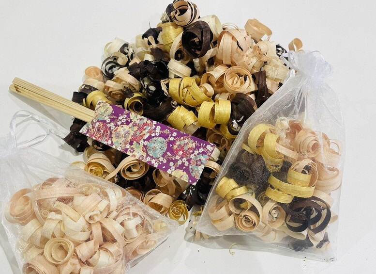 A collection of ribbon-like materials in various colors and textures, including beige, black, and yellow, with a decorative card and chopsticks. 2