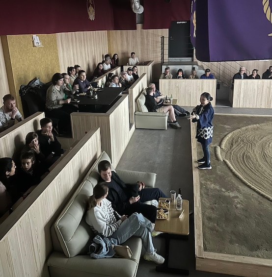 A conference room with people seated and a presenter standing. 2