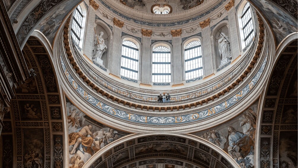 A grand architectural interior with a central dome, ornate frescoes, and classical statues. 5