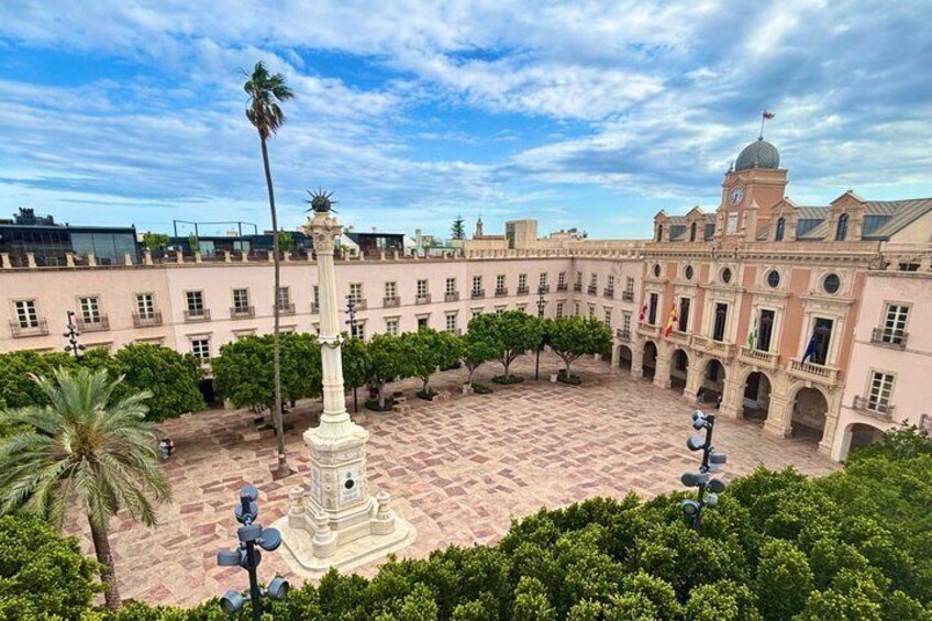 A courtyard with a central fountain, surrounded by buildings with classical architecture and palm trees. 3