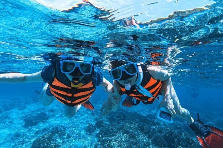 Two people snorkeling underwater. 1