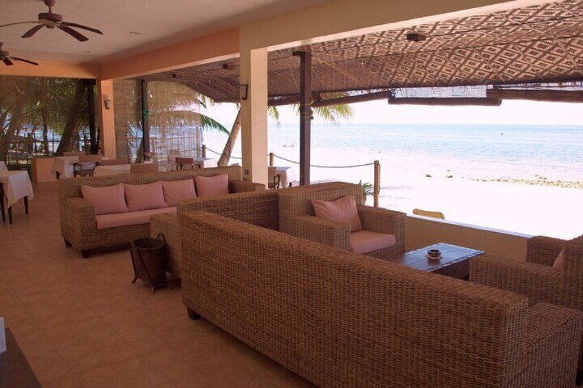 A beachside lounge with wicker furniture and a view of the ocean. 2