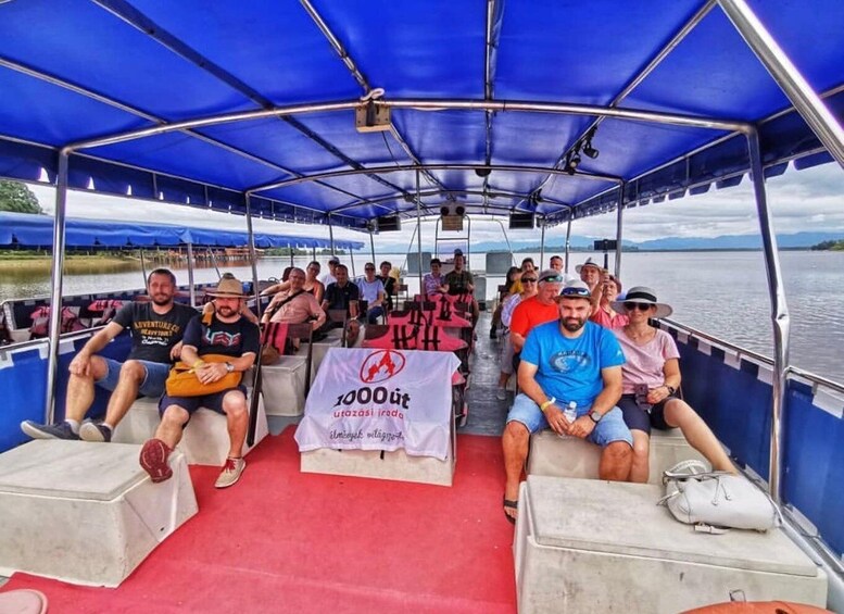 A group of people on a boat with a banner reading '1000 ut'. 3