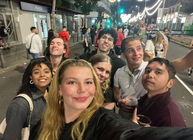 Un gruppo di persone si fa un selfie in strada di notte. 3