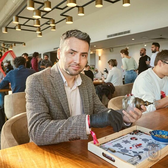 A person seated at a table with a board game, a jar, and a bowl of snacks. 4