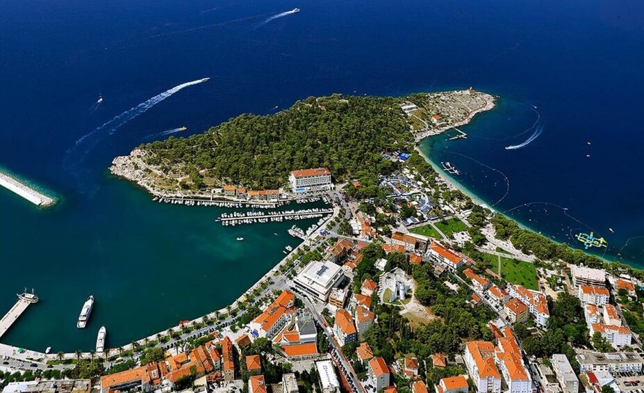 An aerial view of a coastal town with a central island, a marina, and surrounding water. 3