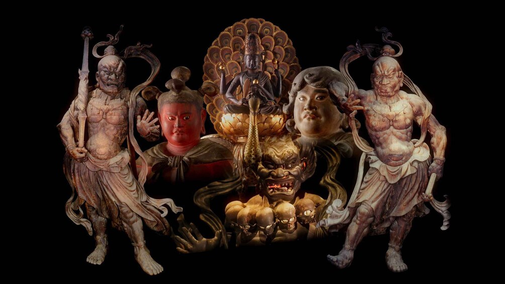 A collection of statues, including a central figure with a peacock-like headdress and multiple smaller figures. 2