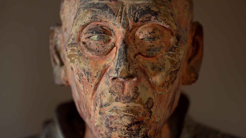 A weathered sculpture with visible erosion and discoloration. 3