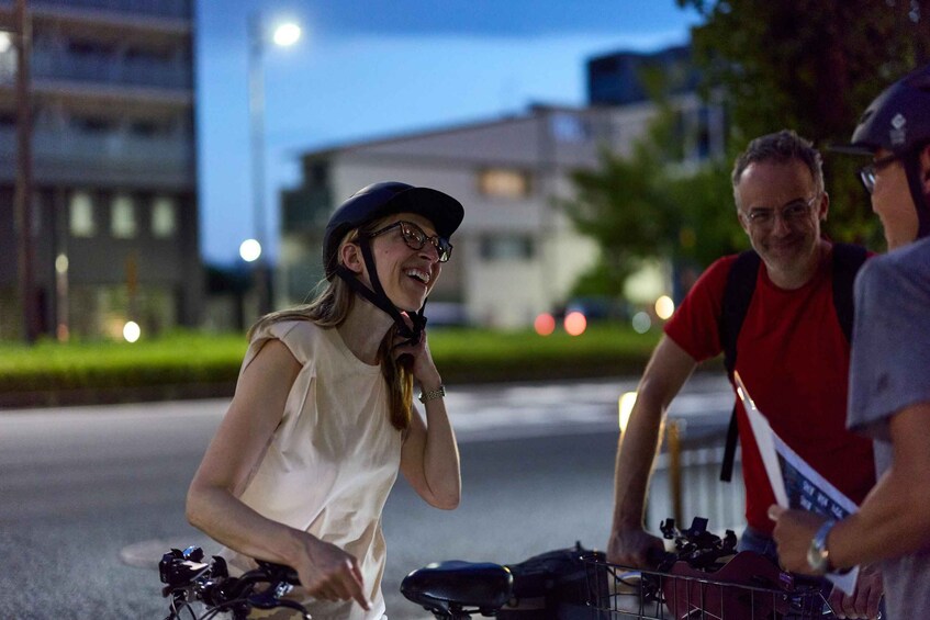A person riding a bicycle on a city street at night. 5