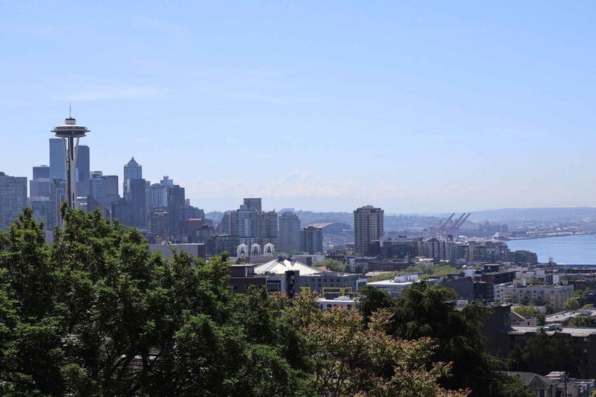 A city skyline with a prominent tower, dense urban buildings, and a body of water in the background. 5
