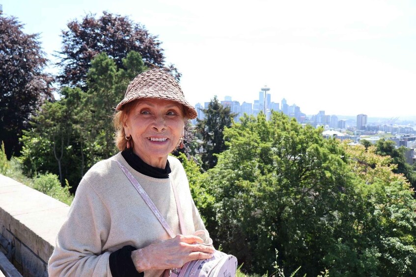 A person sitting on a stone bench with a city skyline in the background. 1