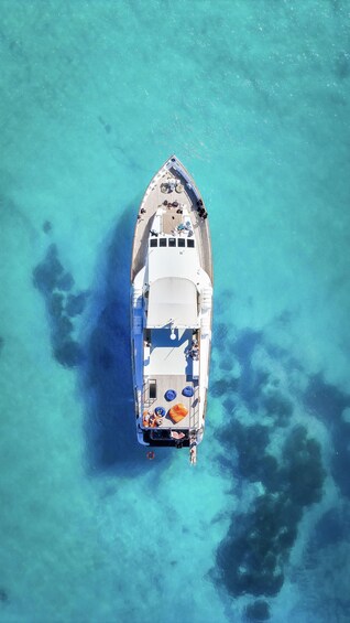 An aerial view of a boat docked in clear turquoise waters. 2